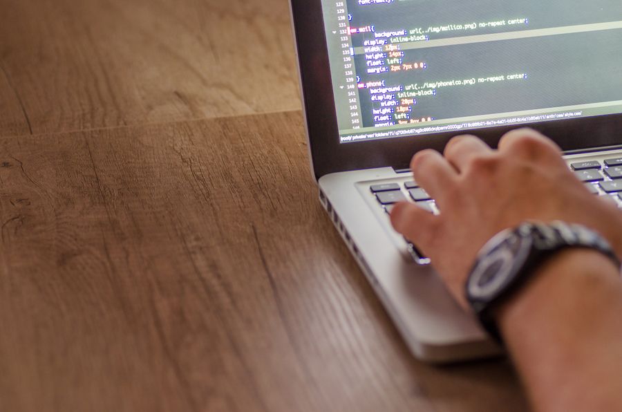 Developer writing application code on a laptop