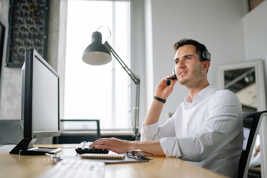 Person answering a phone enquiry while working at a computer