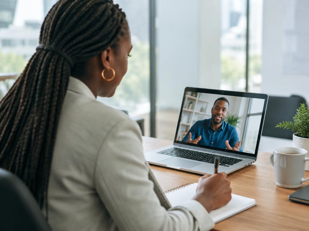 Consultant on a video call with a business owner, taking notes